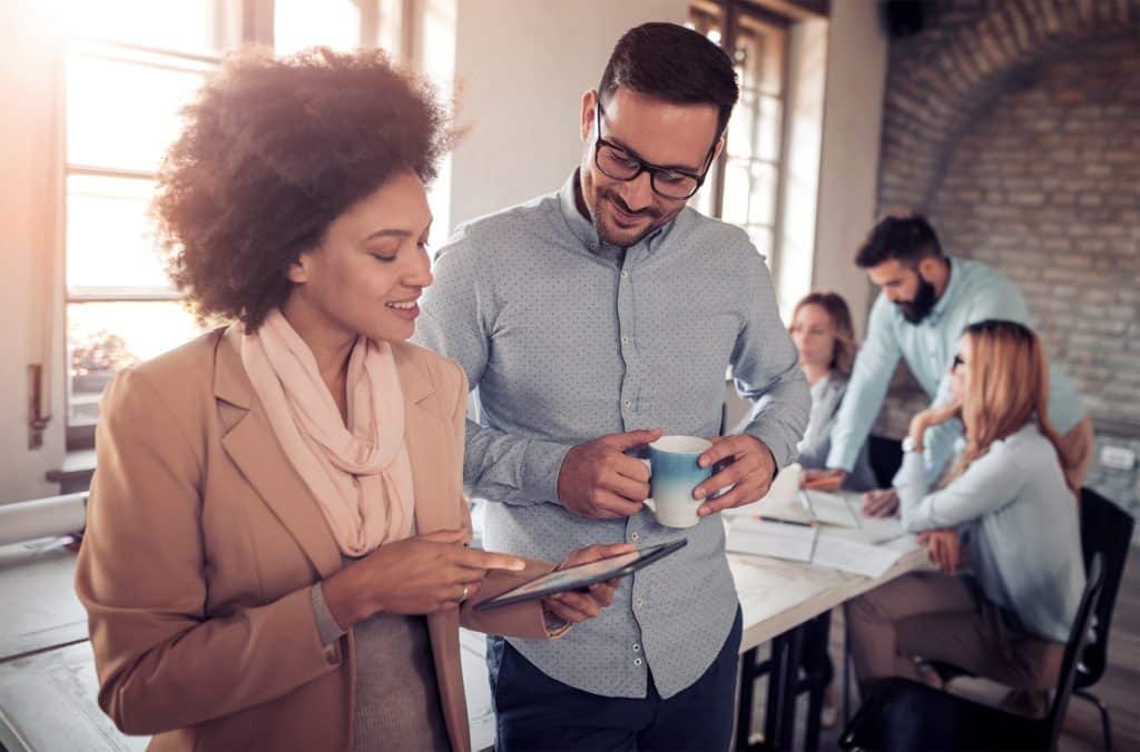 Two people looking and smiling at a paper that one of them is holding